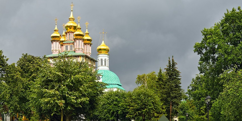 The Golden-domed cathedral complex surrounded by green trees, top places to visit near Moscow.